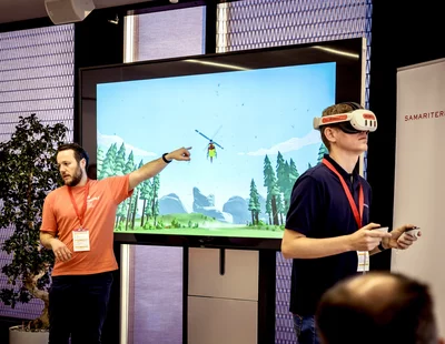 Ein Mann präsentiert eine virtuelle Realität mit einem Helikopter auf einem Bildschirm.