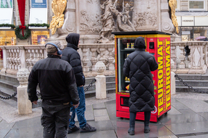 Menschen vor Teuromaten am Graben