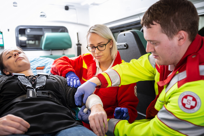 Sanitäterin und Sanitäter mit Patientin