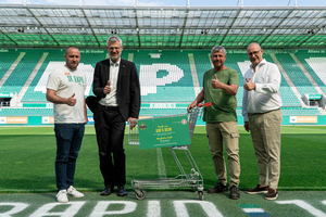 Vier Männer innerhalb des Allianz Stadions von Rapid Wien. Oliver Löhlieb und Georg Jelenko vom Samariterbund Wien übergeben ein 