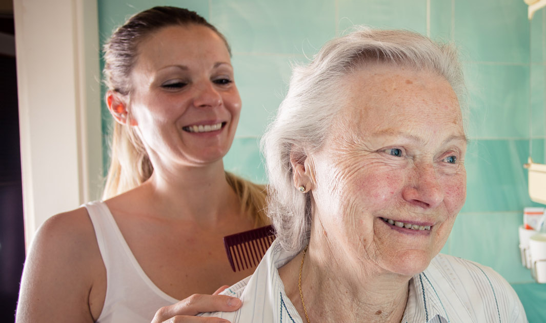 24-Stunden-Betreuungskraft hilft Kundin beim Haare kämmen