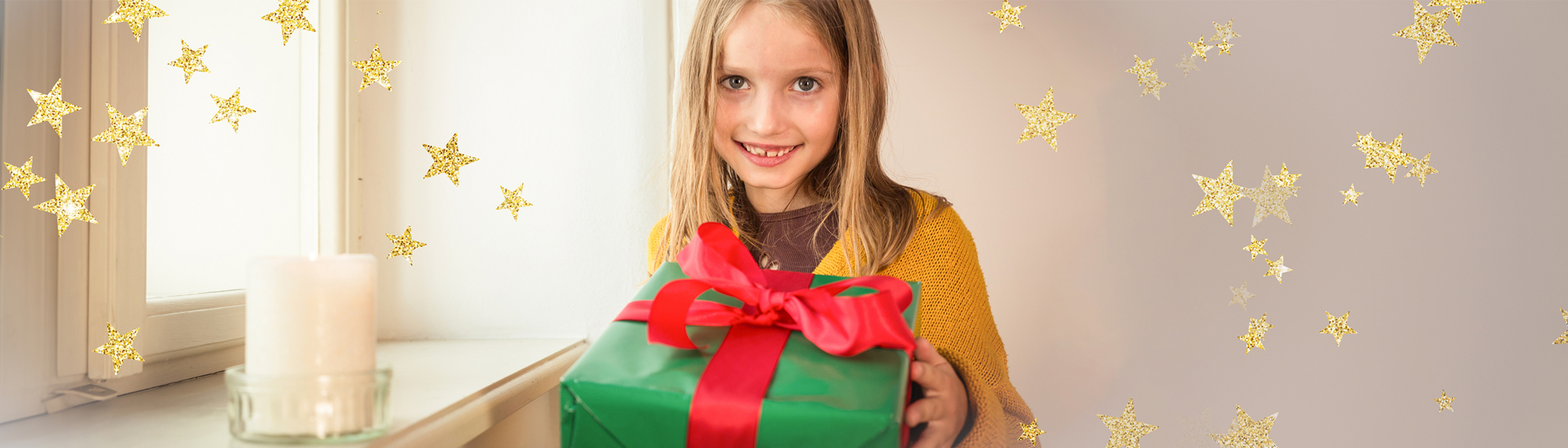 Lachende Kind mit Geschenk in den Händen