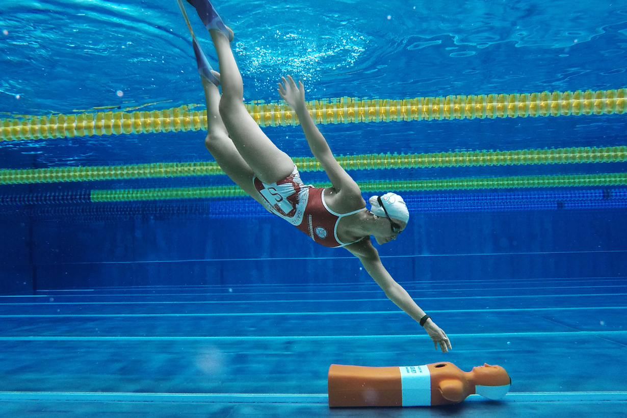 Rettungsschwimmerin taucht in Schwimmbecken nach Rettungspuppe