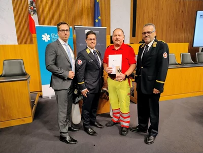 Vier Männer stehen im Parlament.