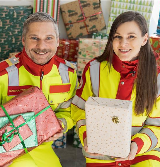 Samariterbund-Mitarbeiter:innen halten Spielen Sie Christkind Pakete