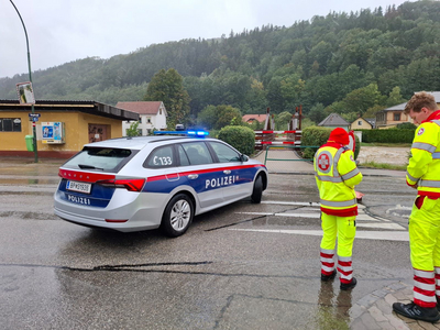 Polizeiauto und Samariter helfen bei Hochwasser