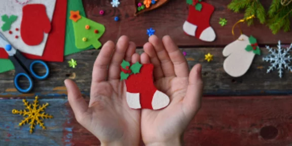 Hand hält Nikolaussocke aus Filz in den Händen
