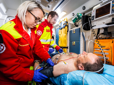 Patient wird im Krankenwagen von Sanitäterin versorgt