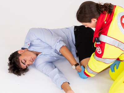 Sanitäterin bringt Patient in die stabile Seitenlage.