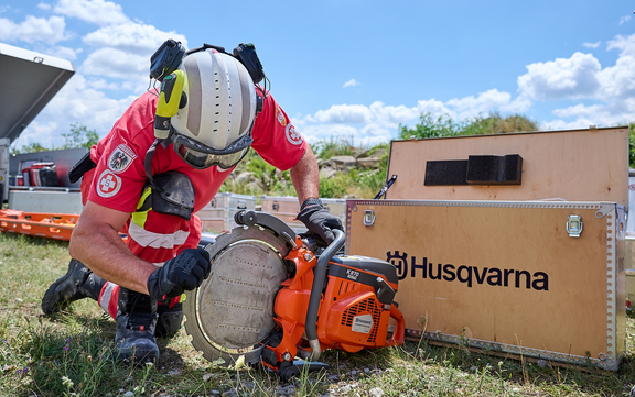 Einsatzkraft der Samariterbund Katastrophenhilfe präsentiert Kettensäge von Husqvarna