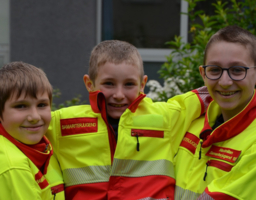 Drei Jungen mit Einsatzuniform, schauen in die Kamera