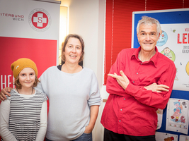 Aufnahme in LernLEO Einrichtung bei einer Lesung, links Johanna, Mitte Petra Hartlieb und rechts Marko Simsa, im Hintergrund Roll up Samariterbund Wien und Plakate von LernLEO